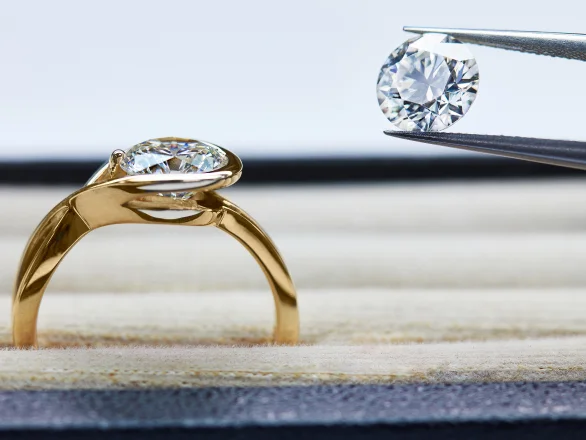 Person applying details to floral jewelry with a brush in a workshop