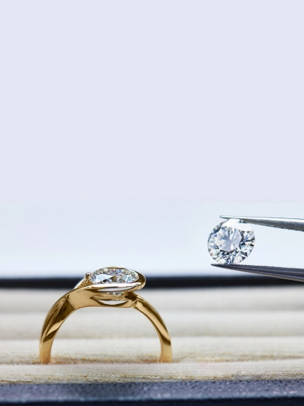 A smiling man wearing a black Pandora t-shirt works at a crafting table with Pandora boxes stacked in front of him